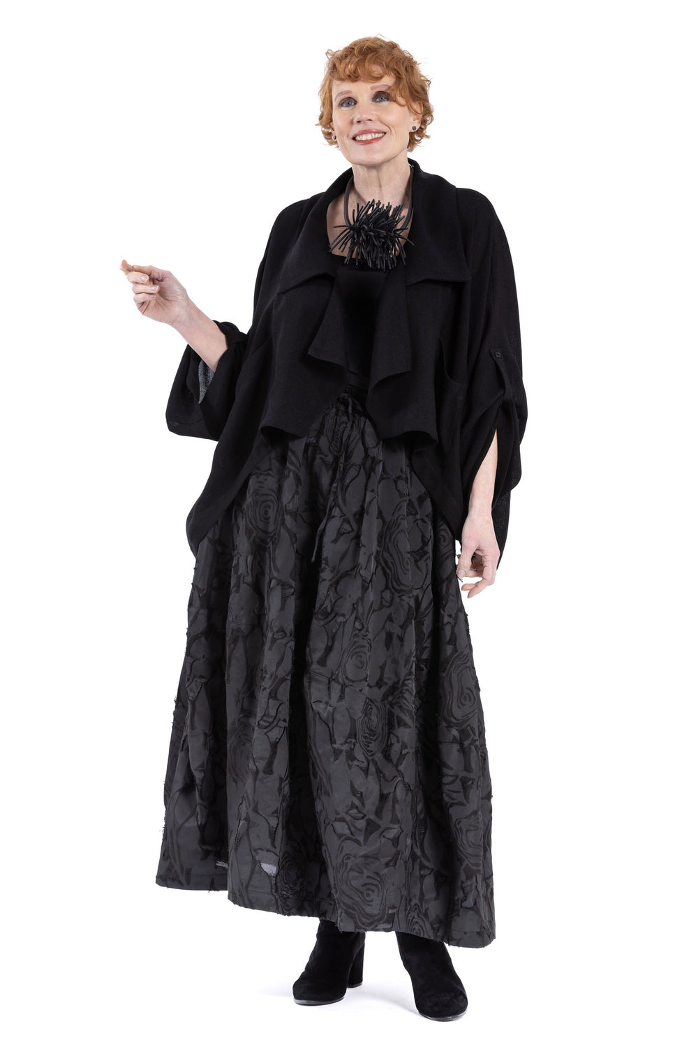 Cropped black lapel jacket with drape collar and patch pockets.