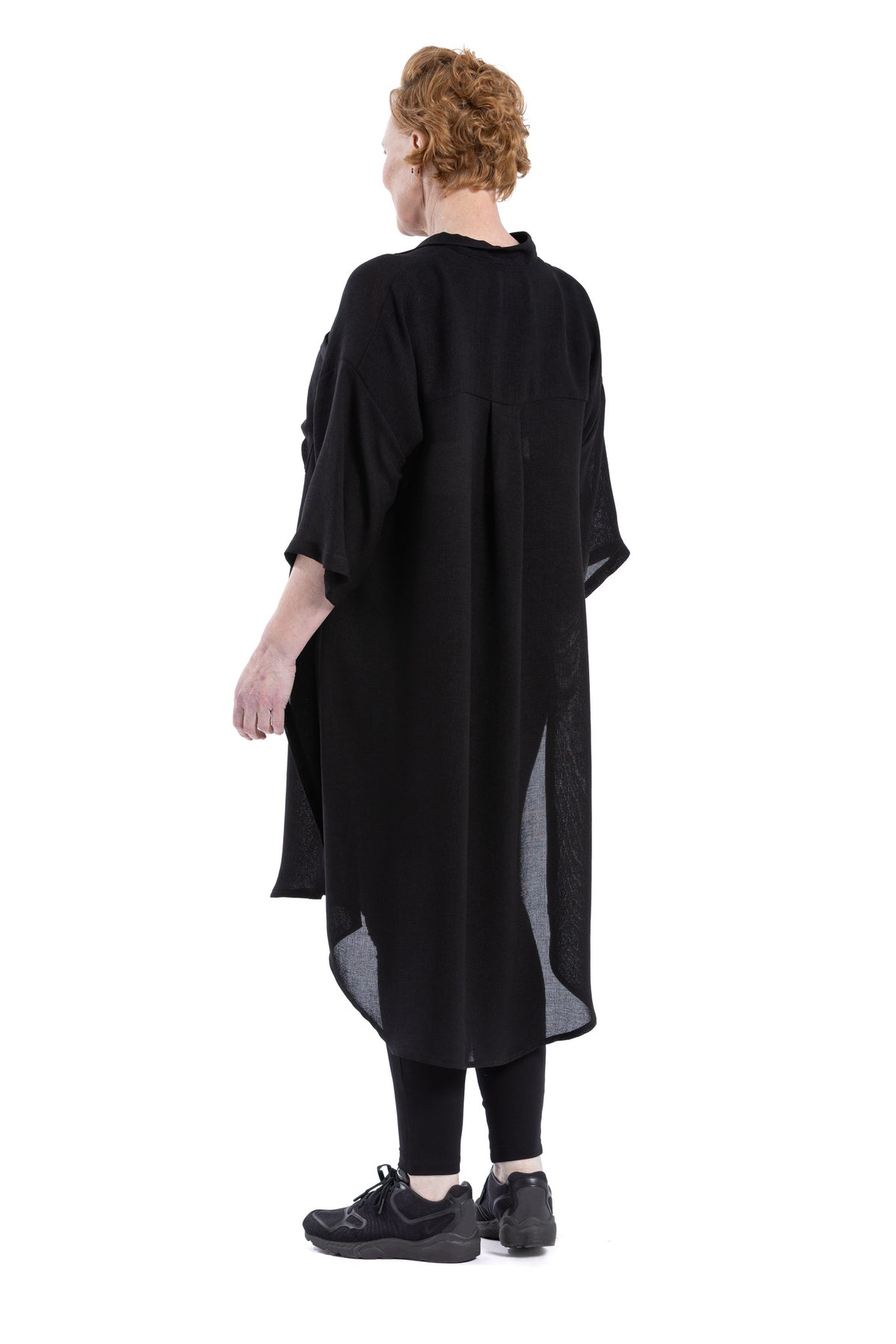 Back view of black oversized shirt dress showing scooped hem.